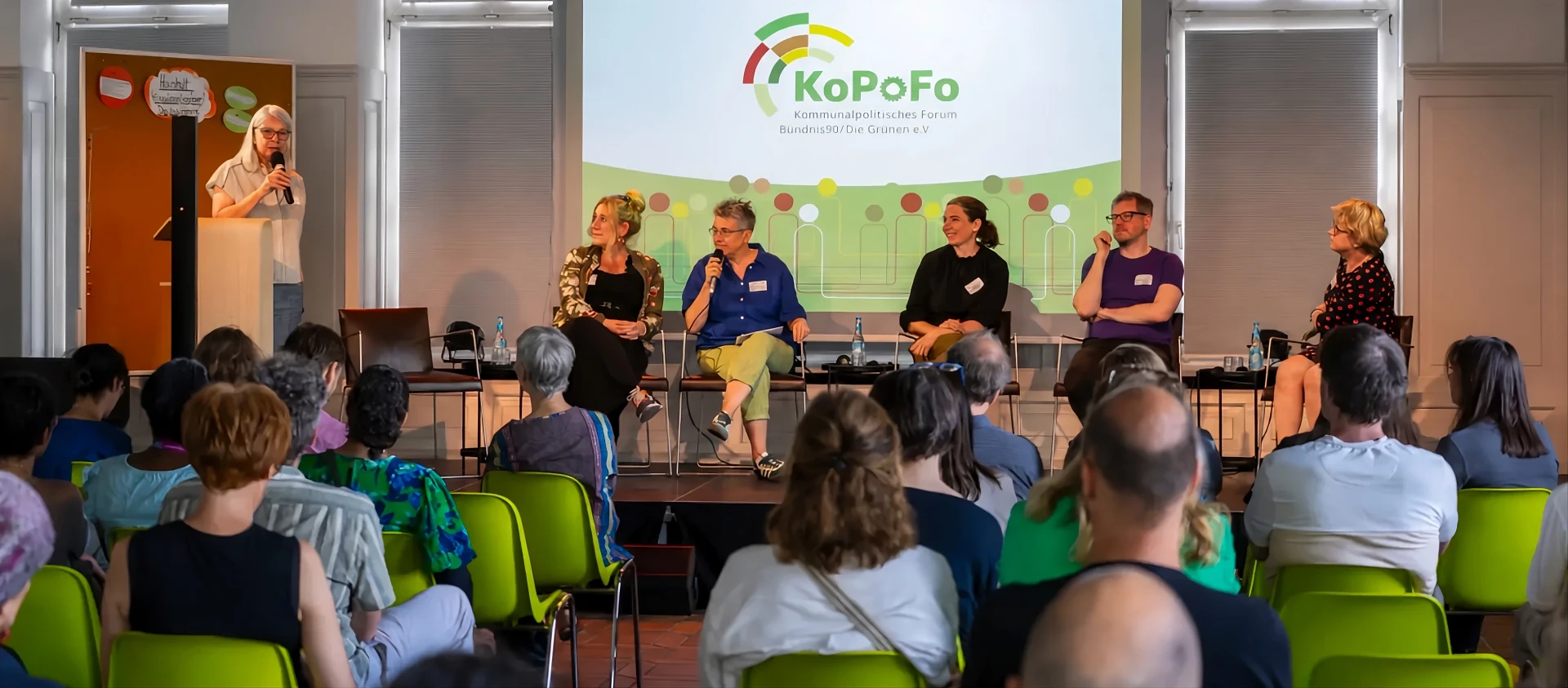 Mehrere Personen diskutieren auf einem Podium vor Publikum inklusive der Vorstandsvorsitzenden Monika Herrmann